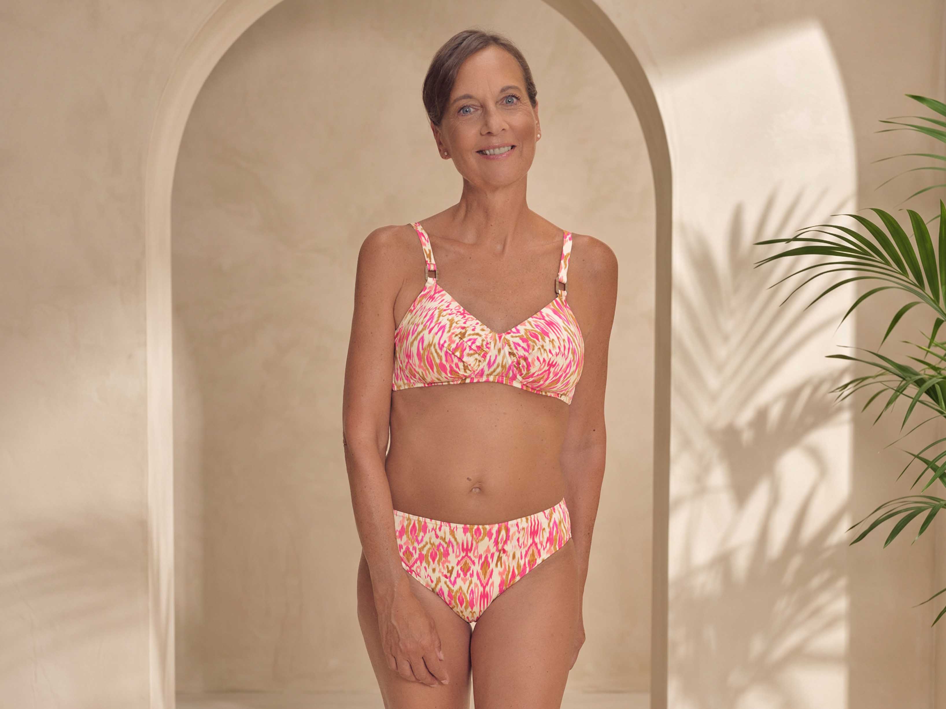 Ikat-inspirierter Print in Pink- und Erdtönen mit chlorresistentem Material, UV-Schutz 50+ und seitlichem Halt für Prothesen.